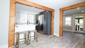 Una cocina moderna con una isla central, vigas de madera y vistas al exterior.