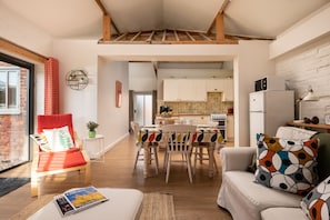 A modern interior with a dining area, kitchen, and seating space.