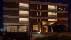Un hôtel moderne à plusieurs étages, doté de grandes fenêtres et d’une enseigne « HÔTEL » bien visible.