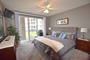 A bedroom with a large bed, a ceiling fan, a TV mounted on the wall, and a window with a view of a building outside. - Welcome to Paradise!Screened Patio-LANDS END 12 x 36 Boat slip  Sleeps 6-8
GRILL (Osage Beach)