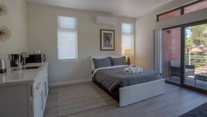 Ein modernes Schlafzimmer mit Bett, Nachttisch und Blick ins Freie.