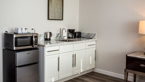 A compact kitchen with a microwave, coffee maker, and a sink.