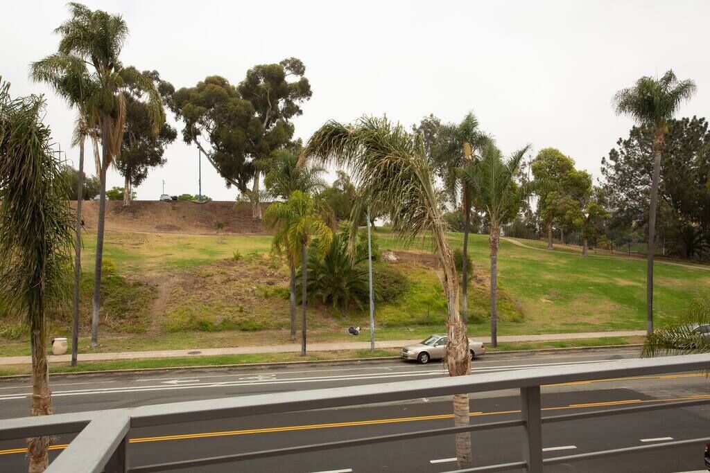 Una carretera con baranda de seguridad y palmeras.
