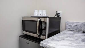 Una cucina compatta con forno a microonde integrato e frigorifero.