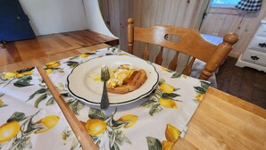 Une table à manger avec une assiette de toasts et une fourchette, le tout posé sur une nappe à motifs de citron.