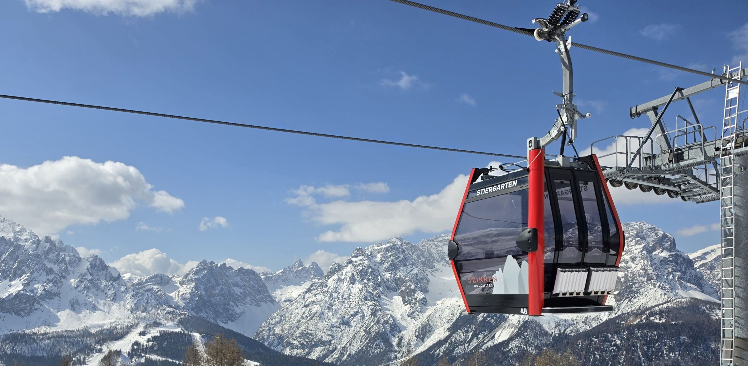 A cable car suspended over a mountainous landscape.