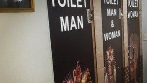 A row of bathroom stalls with signs indicating 'TOILET MAN' and 'TOILET WOMAN'. - Downtowninn (Cairo)