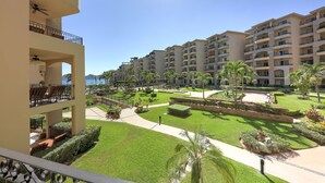 A multi-story hotel with balconies, a pool area, and well-maintained gardens. - Third-Floor Luxury: Ocean & Land's End Views  - Villa La Estancia 1308 (Cabo San Lucas)