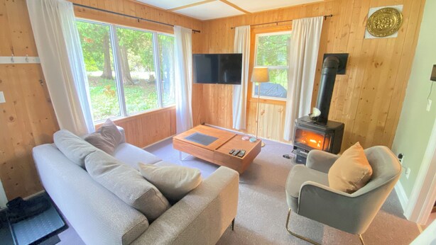Un acogedor interior de cabaña con sofá, sillón y chimenea.