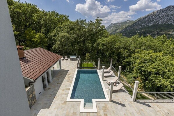 Una piscina con vistas a montañas y árboles.