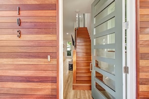 Un mur en bois orné des chiffres 1, 0 et 3, un escalier et une porte avec des panneaux de verre.