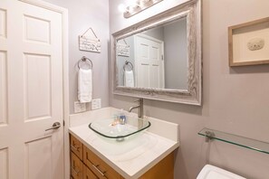 A bathroom with a glass sink, a large mirror, a towel rack, and a framed picture on the wall. - Great rates at Kihei Bay Surf G259 Comfortable Studio Space! (Kihei)