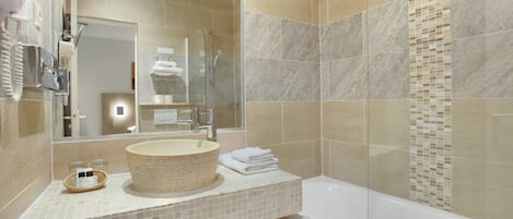 A modern bathroom with a large mirror, a round sink, a bathtub, and a shower area.