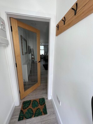 Enter a hallway leading to a dining area with a table and chairs.