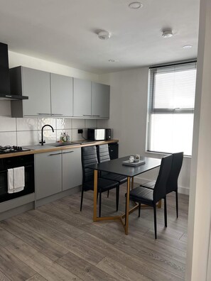 Enjoy cooking and dining in this stylish kitchen with a central island, stainless steel stove, and sleek cabinetry.