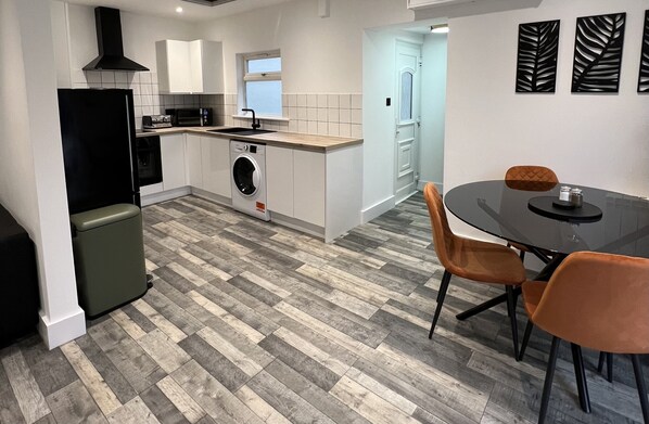 Enjoy meals in the compact kitchen with a dining area featuring a round table and matching chairs.