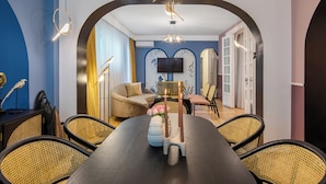 A dining area with a long table, chairs, and a central candle holder. - Birds of Paradise (Bucharest)