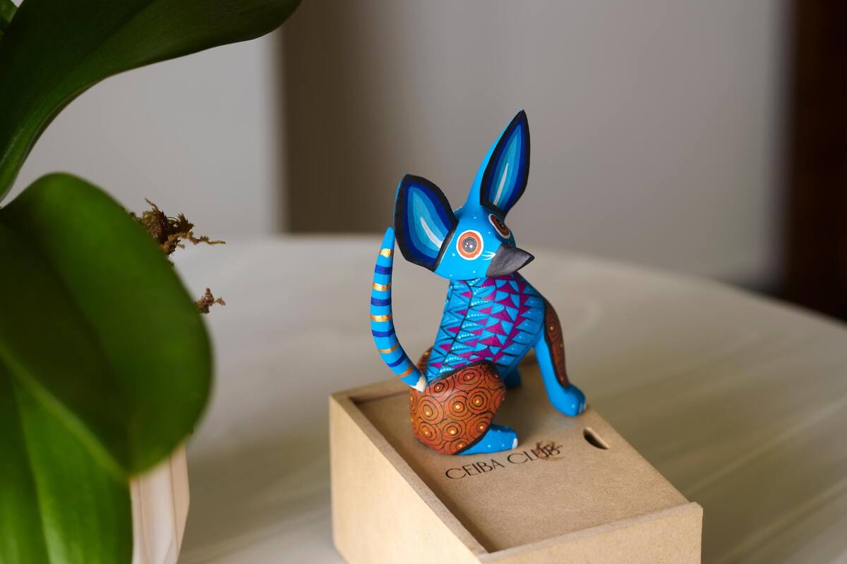 Une figurine de lapin en céramique, posée sur une boîte en bois, sur laquelle on peut lire l'inscription « CEIBA CLUB ».