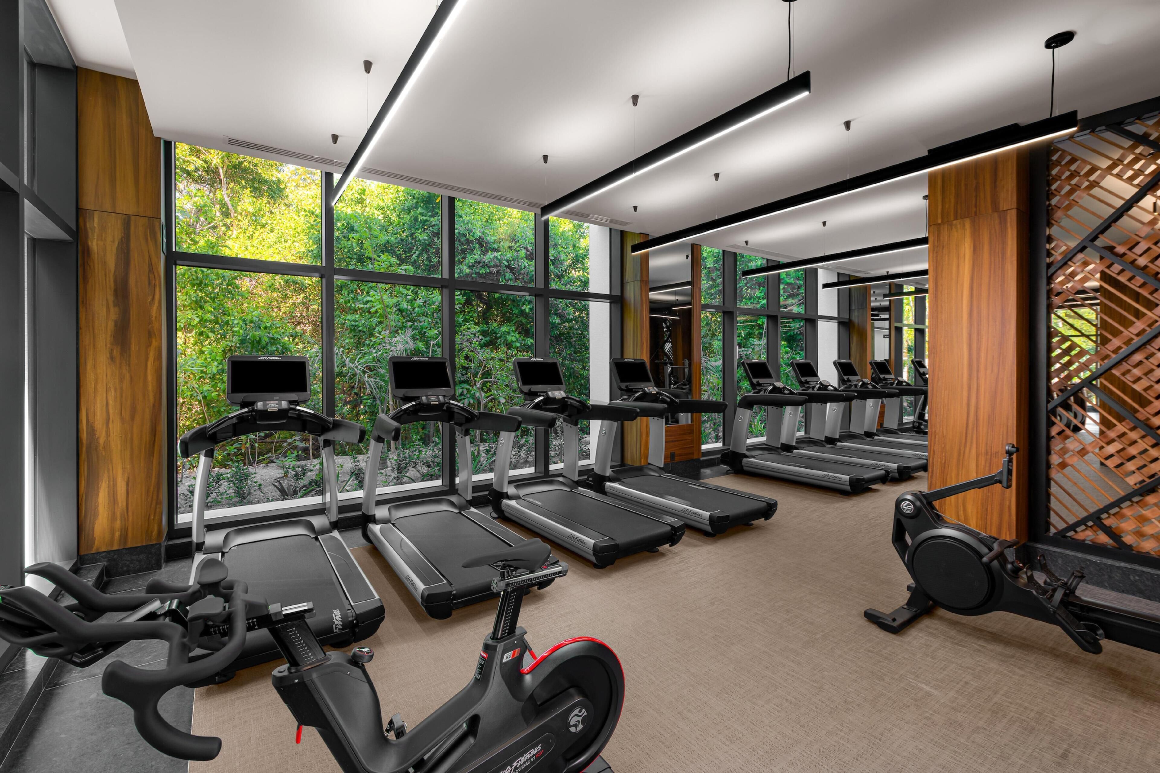A gym with multiple treadmills, stationary bikes, and exercise equipment.