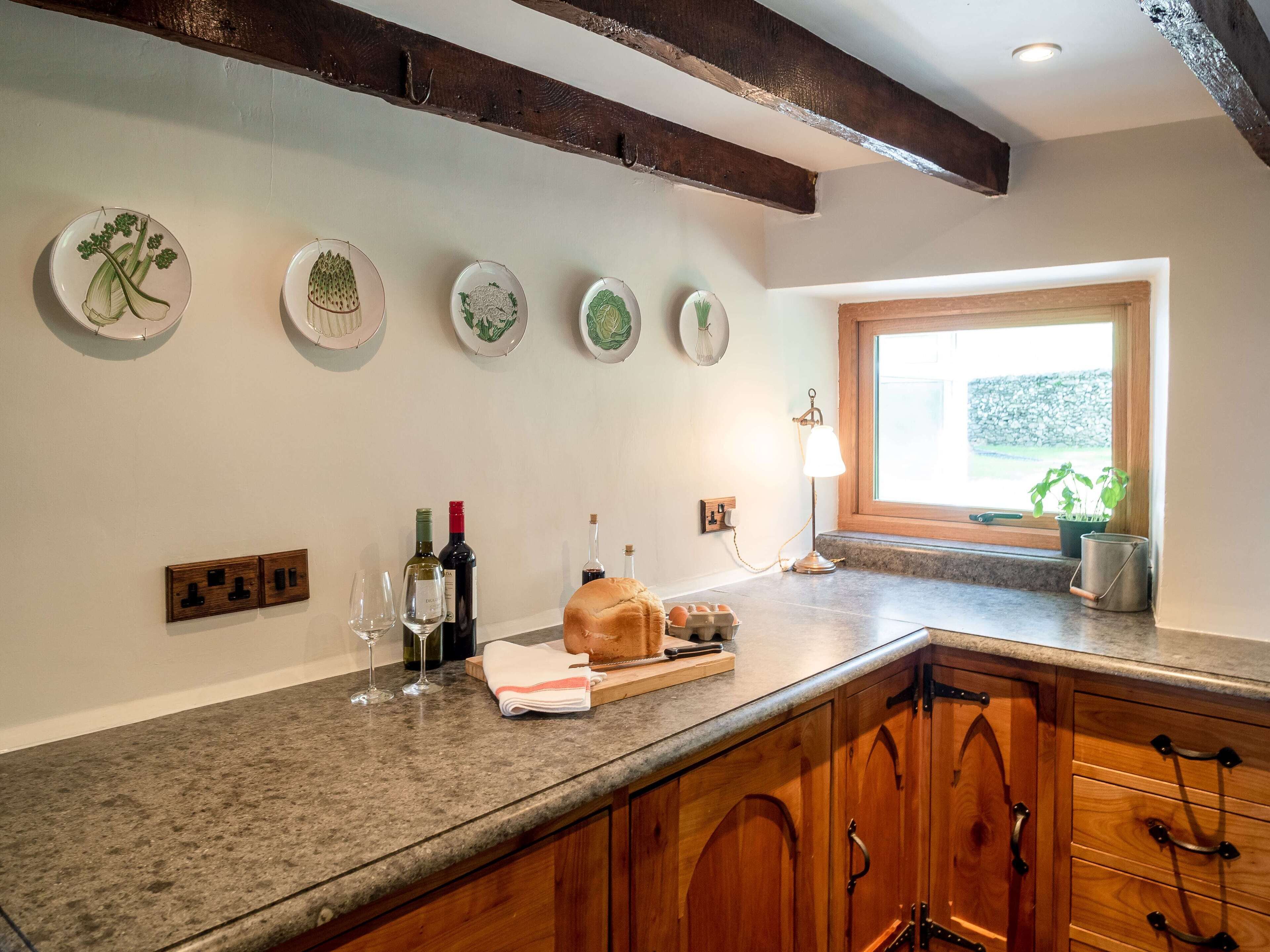 A kitchen with granite countertops, wooden cabinets, and a window with a view.