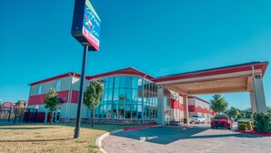 A hotel with a modern design, featuring a large glass facade and a red and white color scheme. - Express Inn & Suites (Norman)