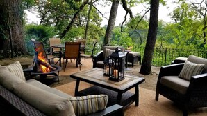 An outdoor seating area with a fire feature, cushioned furniture, and a table with candles.