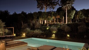 A nighttime pool area with lounge chairs and a pergola. - Sentiero Iconic Villa, a Serene Retreat (Zakynthos)