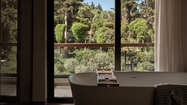 A modern bathroom with a freestanding bathtub, large windows offering a view of a forested landscape. - Sentiero Iconic Villa, a Serene Retreat (Zakynthos)