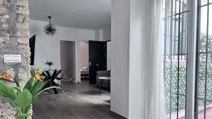 Un espacio habitable moderno con una pared de acento de piedra, una zona de comedor con una mesa redonda y un gran ventanal con vistas a un jardín.