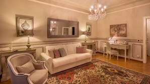 A room with a white sofa, a chair, a desk, and a chandelier. - Αn enchanting residence in front of the Juliet house (Verona)