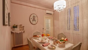 A dining room with a table set for four, featuring a white tablecloth, plates, cups, and a centerpiece with bread and fruit. - Αn enchanting residence in front of the Juliet house (Verona)