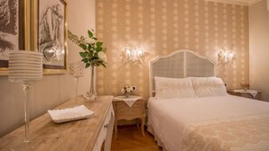 A bedroom with a large bed, a nightstand with a lamp, a dresser, and a framed picture on the wall. - Αn enchanting residence in front of the Juliet house (Verona)