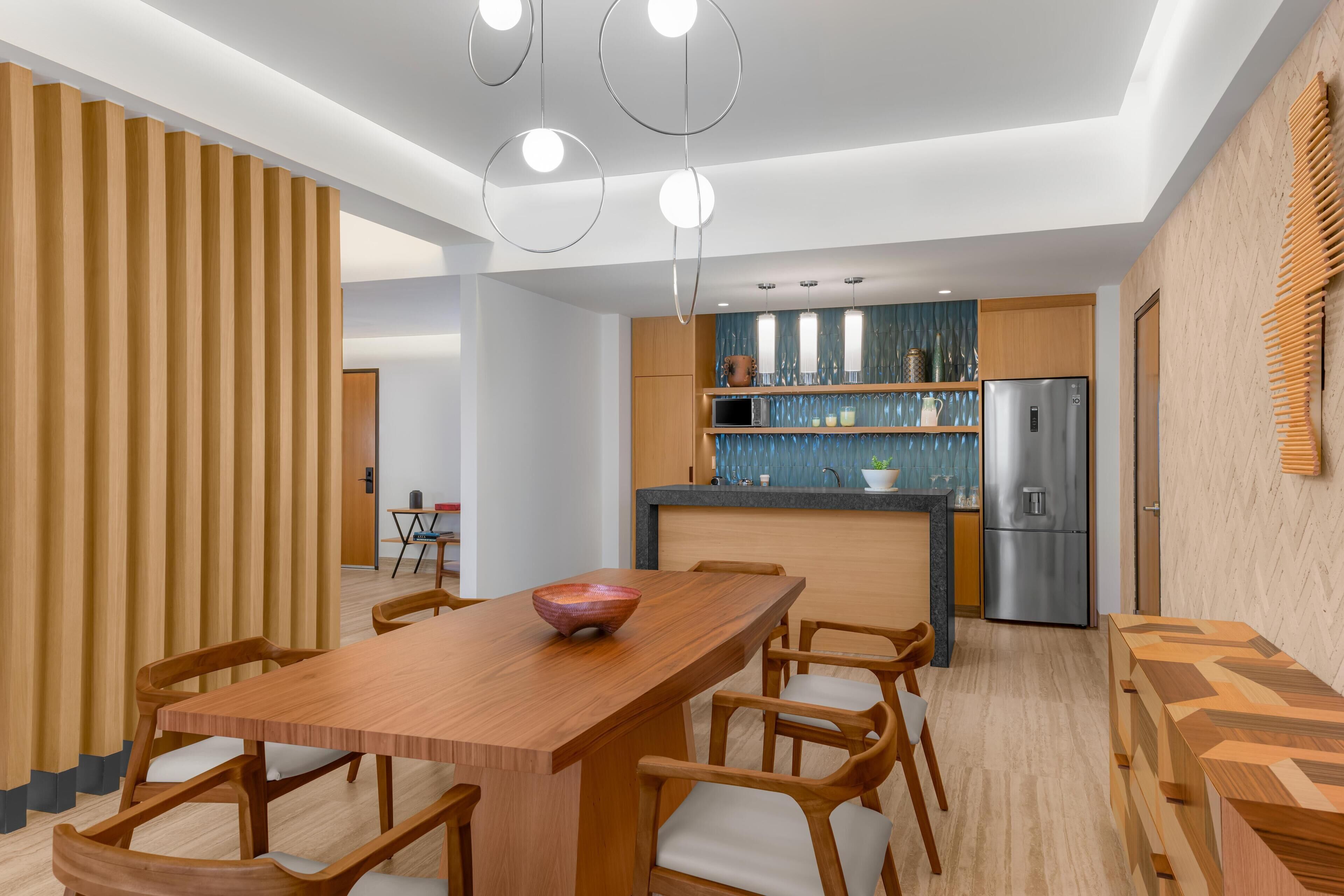 Una cocina moderna con una isla central, armarios de madera y un refrigerador de acero inoxidable.