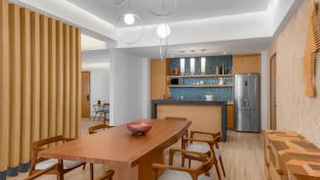 Una cocina moderna con una isla central, armarios de madera y un refrigerador de acero inoxidable.