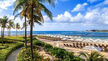 On the beach, white sand, sun-loungers, beach umbrellas
