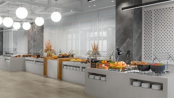 Een moderne buffetopstelling met verschillende foodstations, waaronder fruit, groenten en granen.