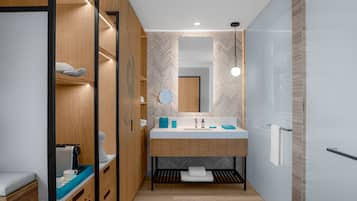 A modern bathroom with a wooden vanity, a sink, and a mirror.
