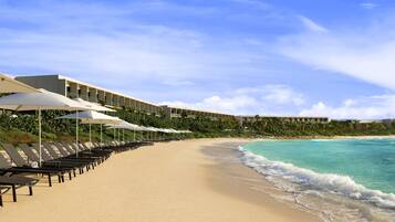On the beach, white sand, sun-loungers, beach umbrellas