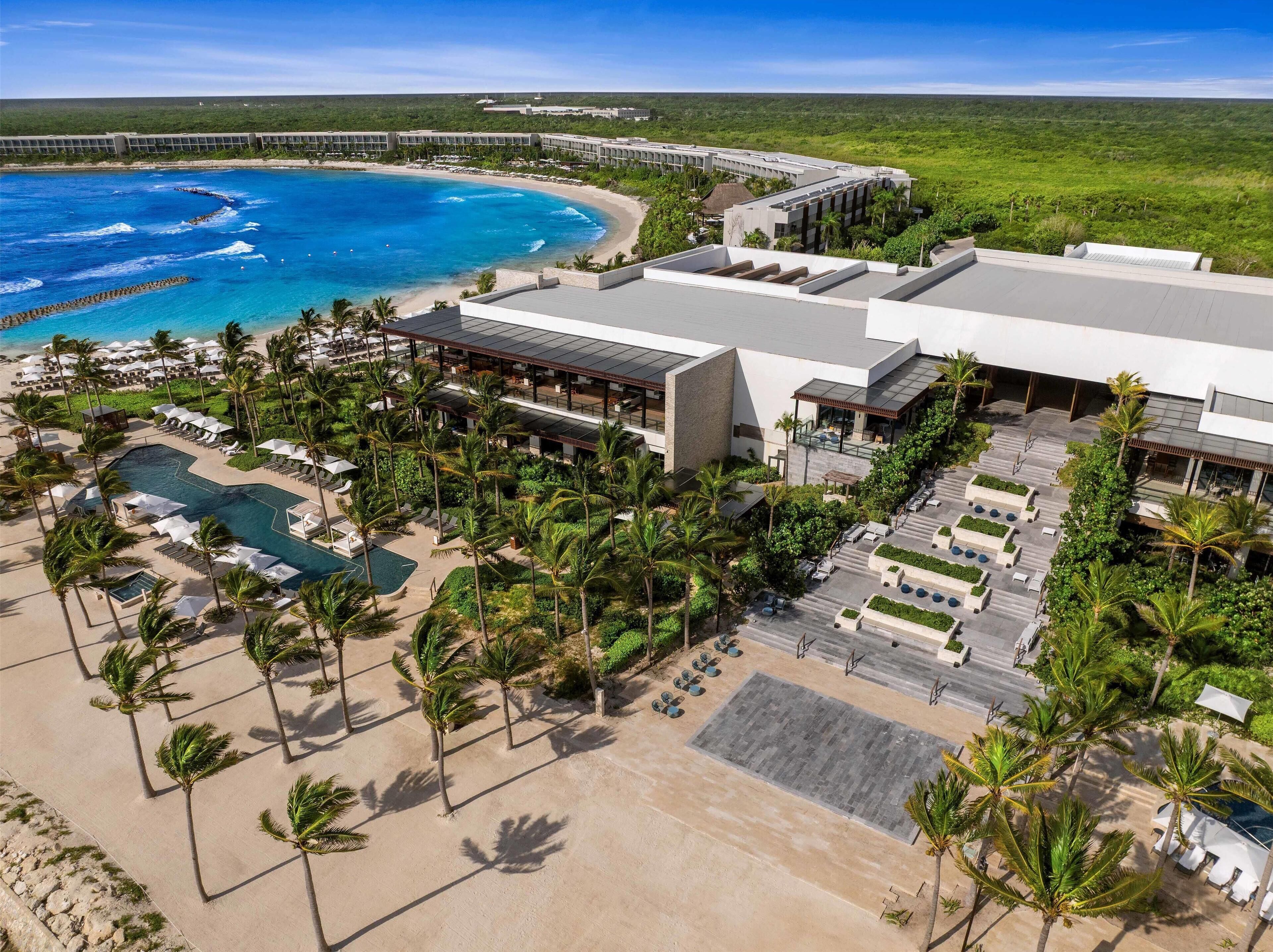 En la playa, playa de arena blanca, camastros y sombrillas 