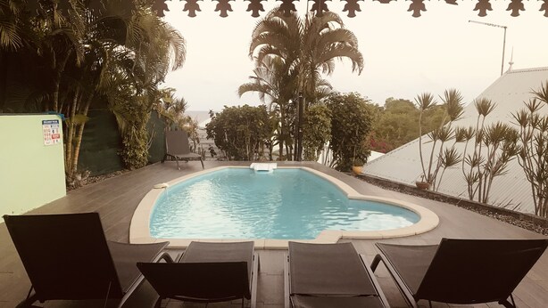 A swimming pool with lounge chairs and palm trees. - Villa SAMA at Clos Samana (Le Diamant)