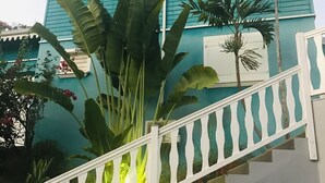A staircase with a white balustrade leading to a blue building with white trim and a white door. - Villa SAMA at Clos Samana (Le Diamant)