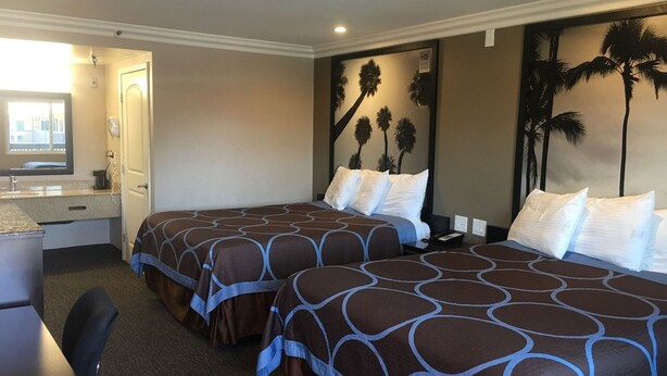 Habitación de hotel con dos camas, un escritorio y una silla.