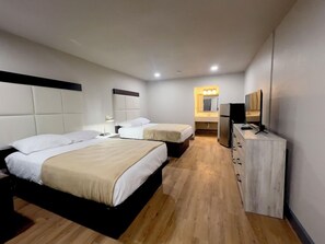A hotel room with two beds, a small kitchenette, a mirror, and a TV. - Howard Johnson Tulsa East/airport (Tulsa)