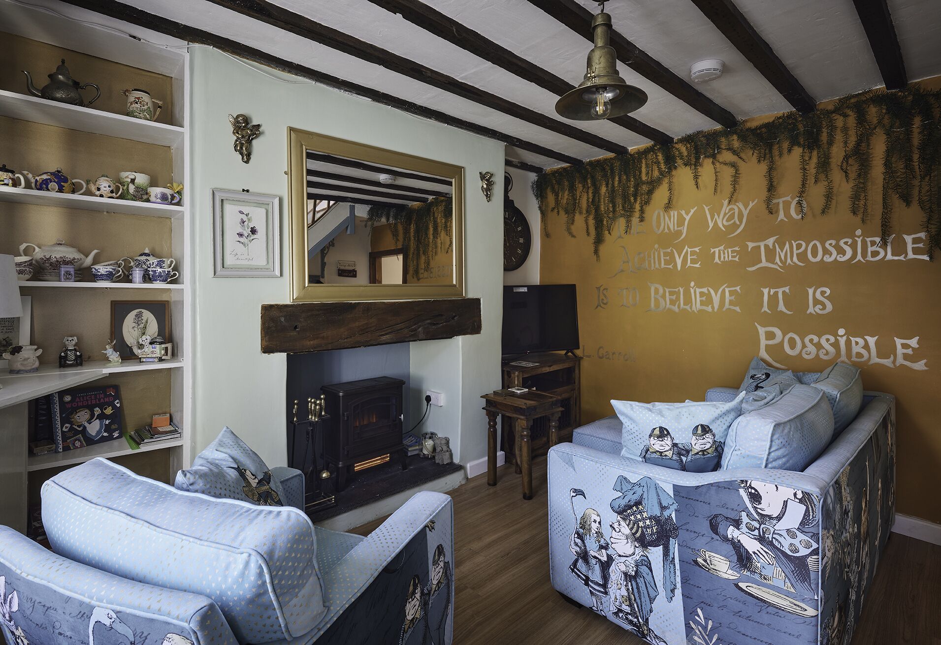A cozy living room with a fireplace, a bookshelf, and a wall with a motivational quote.