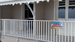 Un bâtiment doté d’un balcon avec une rambarde blanche et d’une enseigne indiquant un lieu situé à Saisonnier.