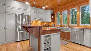 Een moderne keuken met houten kastjes, roestvrijstalen apparatuur en een centraal eiland.