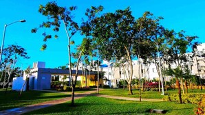 A residential area with modern buildings, a well-maintained lawn, and a clear blue sky. - Casa Gueza (Benito Juarez)
