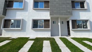 A modern multi-story building with large windows and a flat roof. - Casa Gueza (Benito Juarez)