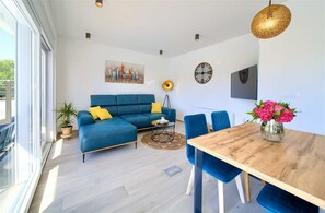 Relax in this stylish living space with a large sofa, dining table, and floor lamp.
