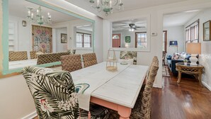 A dining area with a large mirror, a chandelier, and a dining table set for four. - The Funky Swan Shack by Lake Morton & Downtown (Lakeland)